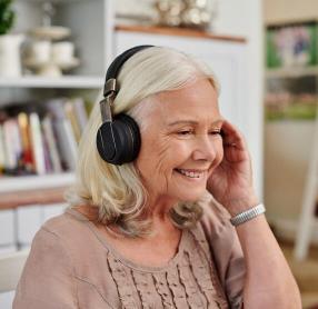 Senior woman listening through headphones